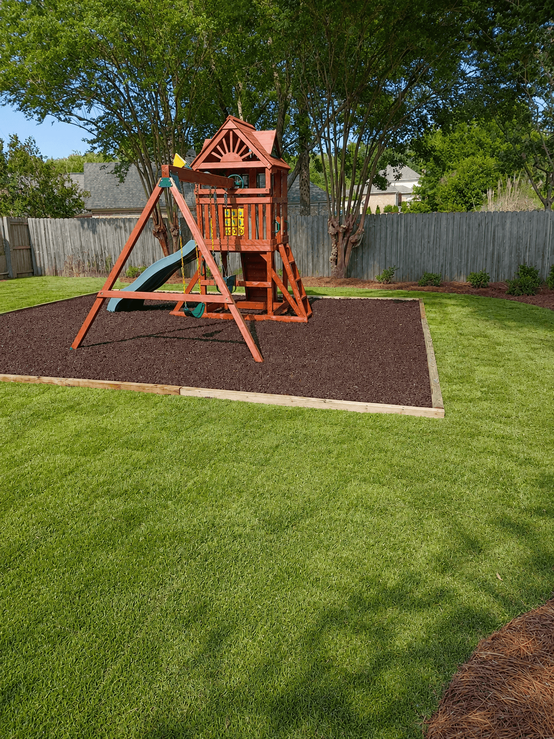 A finished BTOP backyard with fresh sod and a play set